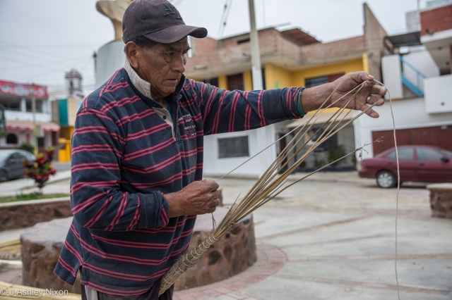 José, fisherman of Huanchaco, Peru constructing a traditional reed boat (Caballito de Totora) on the street. © J. Ashley Nixon